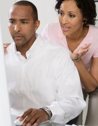 Couple looking into computer screen worried about finances