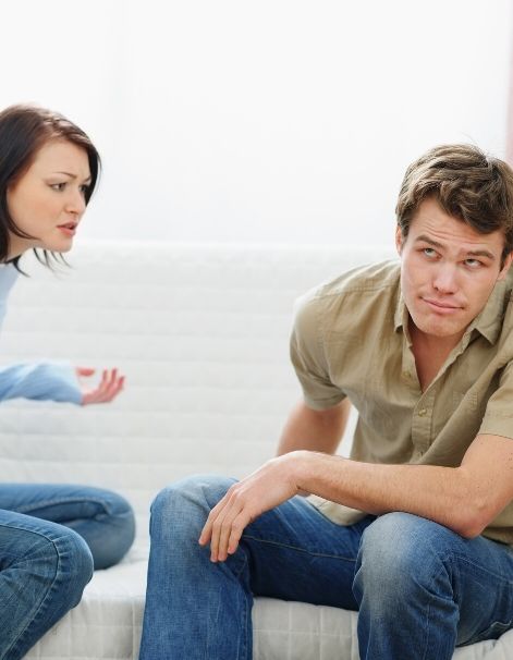 Woman speaking to an uncaring man not listening acting childish