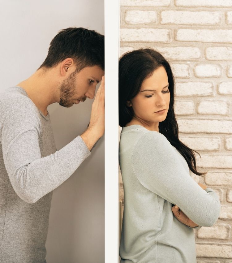 Man leans against a wall with a woman on the other side. This could represent the result of infidelity PTSD. Contact Idit Sharoni for infidelity recovery in Florida, affair recovery, and other services.