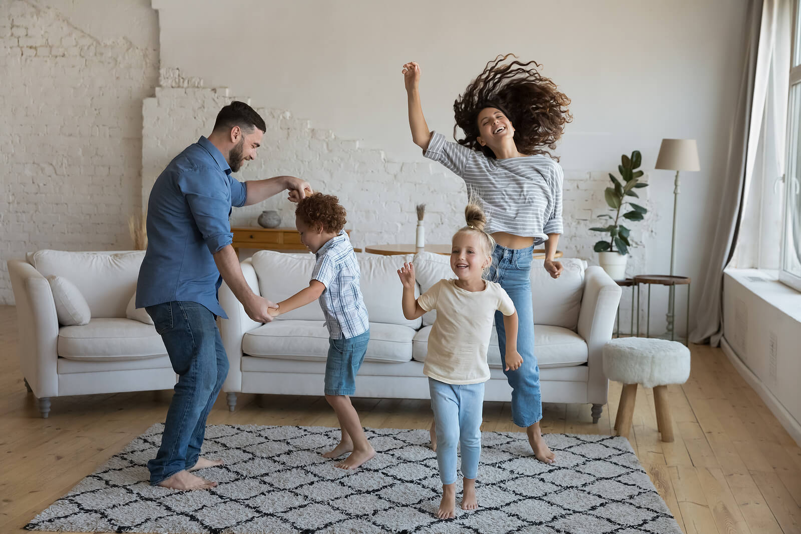 Shows a family dancing in the living room. Represents how a couples therapist In Florida can help you find ways to have fun in your relationship.
