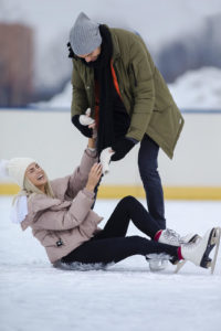 Shows a couple ice skating and the woman fell. Represents how a couples therapist in Naples, FL will support you and your partner having fun in your relationship.