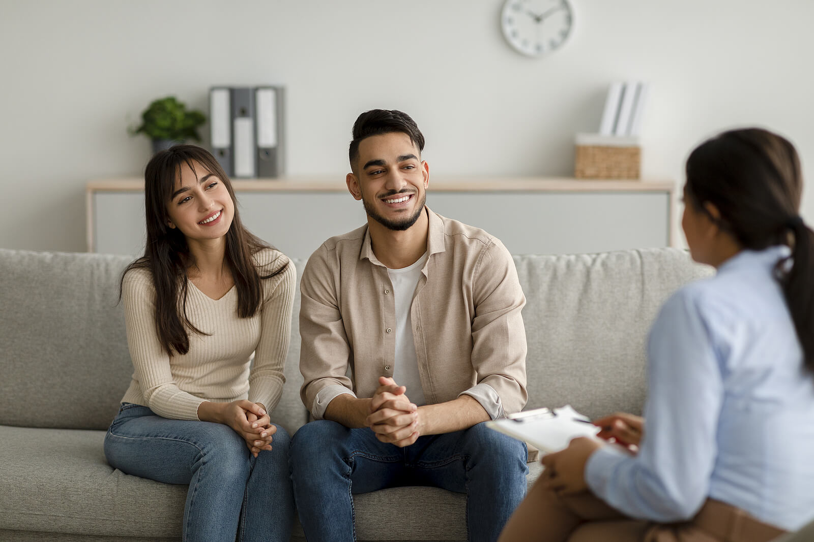 Photo of a couple smiling while in therapy. This photo represents how working with a communication therapist in Florida can help you and your partner to strengthen your relationship.