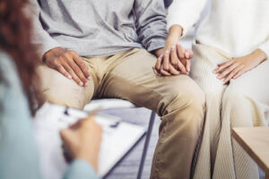 Photo of a couple sitting in therapy with a counselor and holding hands. Facing communication issues in your relationship? Don't wait to get help. With couples therapy in Miami, FL you and your partner can begin communicating more effectively and in a healthy way.
