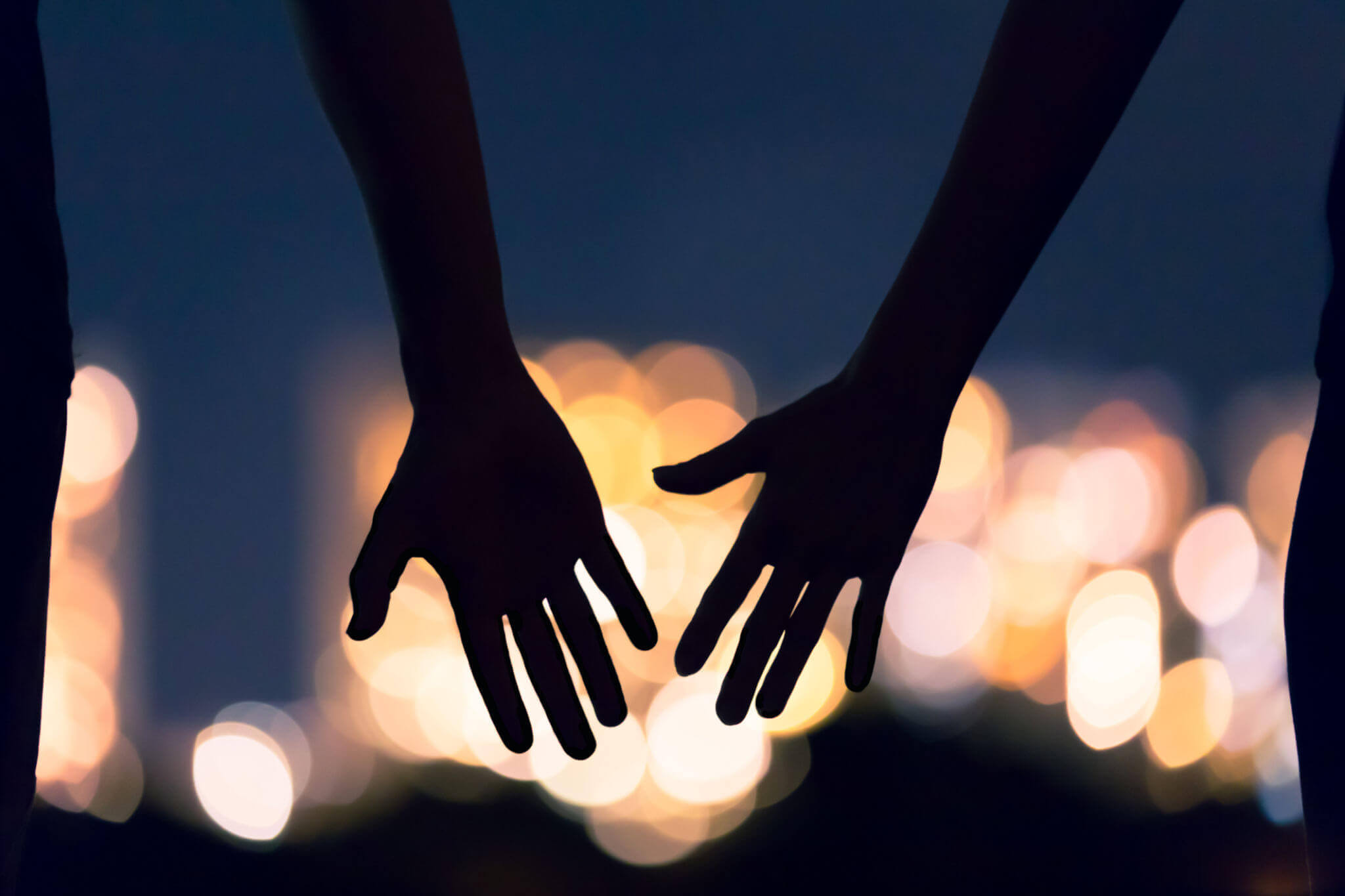 Photo of two hands reaching out to each other at night. Struggling to repair your relationship after an affair? With affair recovery in Florida you can begin learning to trust your partner and heal your relationship.