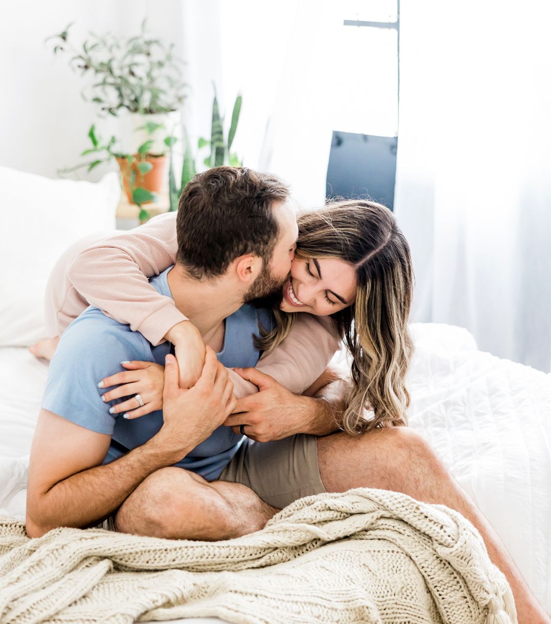 Image of a woman hugging the back of her husband while he kisses her cheek and she smiles. Do you struggle with intimacy issues? Learn tips from a skilled couples therapist on how you can overcome your issues. Find support with couples therapy in Miami, FL.