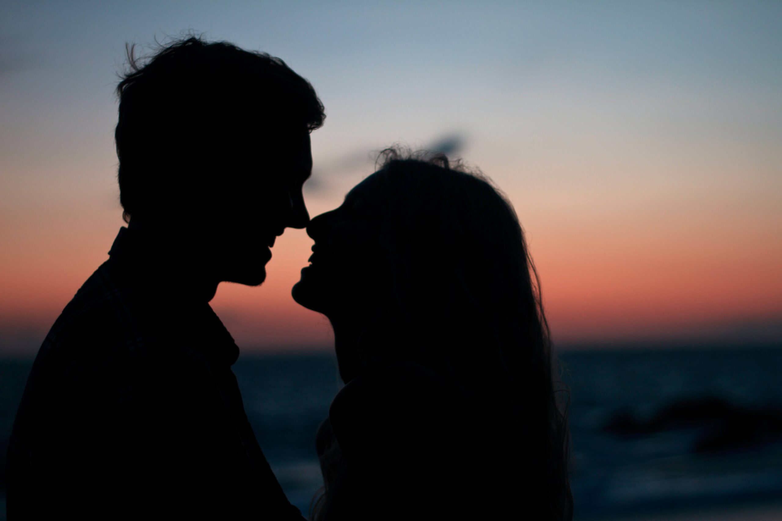 Image of a couple's silhouette on the beach during sunset with their noses together. If you struggle with communication issues in your relationships learn how couples therapy in Miami, FL can help you work through your communication issues. 