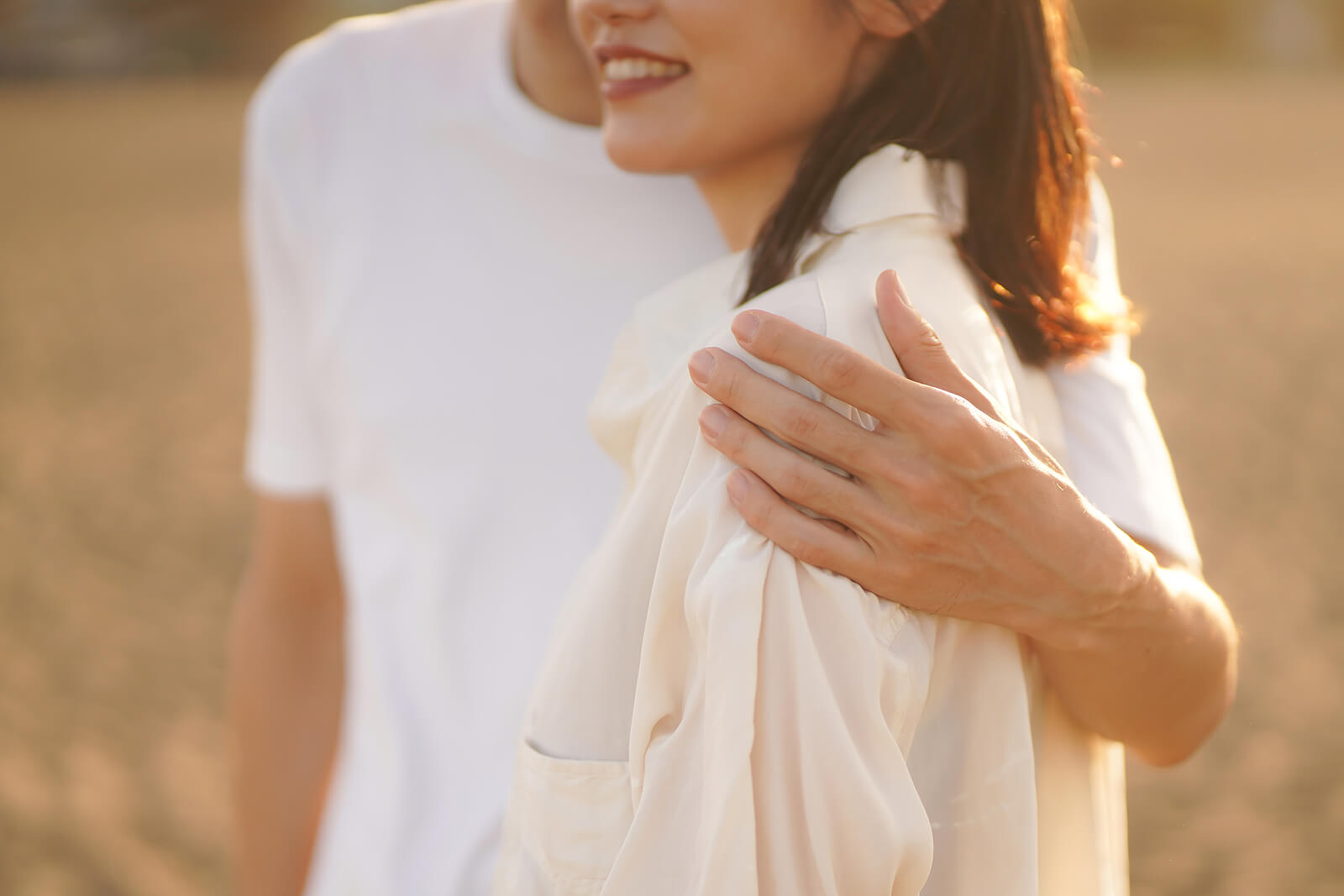 Image of a couple wearing white and standing in a field smiling. With effective communication you and your partner can work through your intimacy issues. Find support with a skilled couples therapist with couples therapy in Miami, FL.