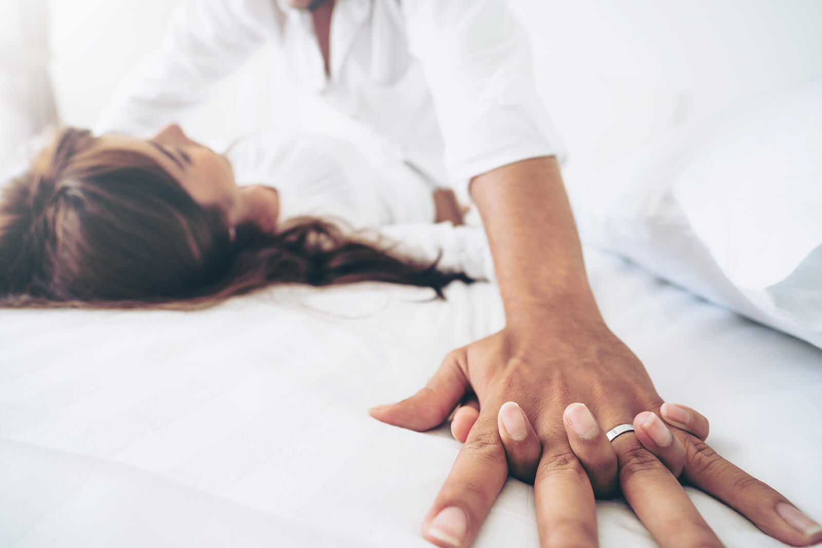 Image of a man and woman laying in bed. If you and your partner are losing intimacy because of communication issues, learn how couples therapy in Miami, FL can help you.
