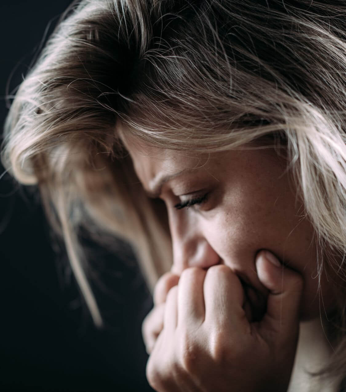 Image of an upset woman covering her mouth with her hands and looking down. Are you suffering from infidelity PTSD? Discover how a skilled therapist can help your relationship with infidelity recovery in Miami, FL!