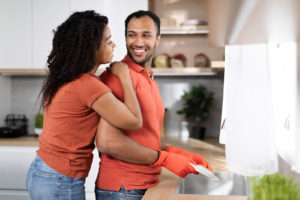 Shows a man doing the dishes and his partner thanking him. Represents how couples therapy and marriage counseling in fl supports a culture of appreciation in a relationship so that each partner feels appreciated.