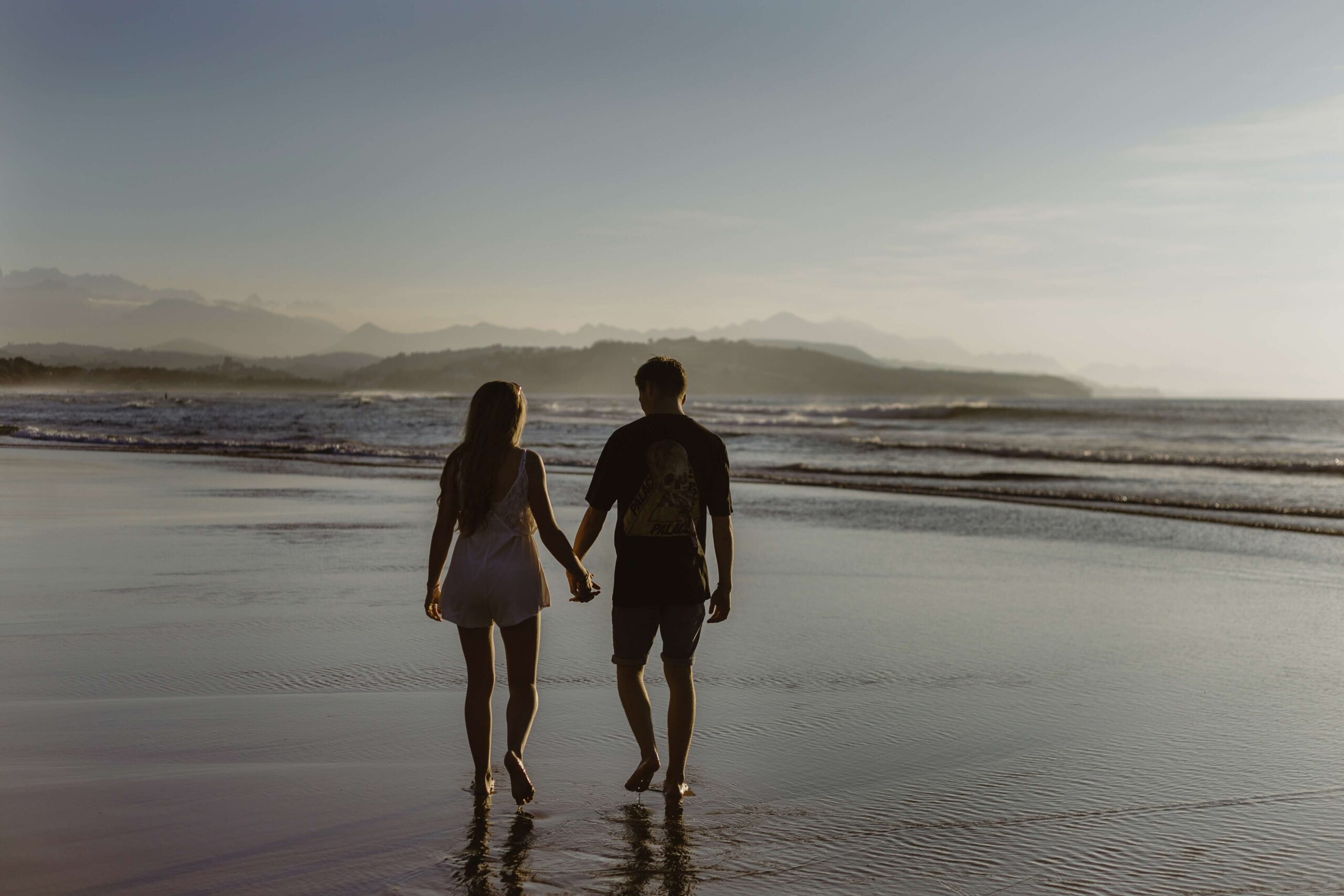 Image of a couple holding hands and walking on a beach during sunset. Discover how online couples therapy in Miami, FL can help you and your partner reconnect in healthy ways.