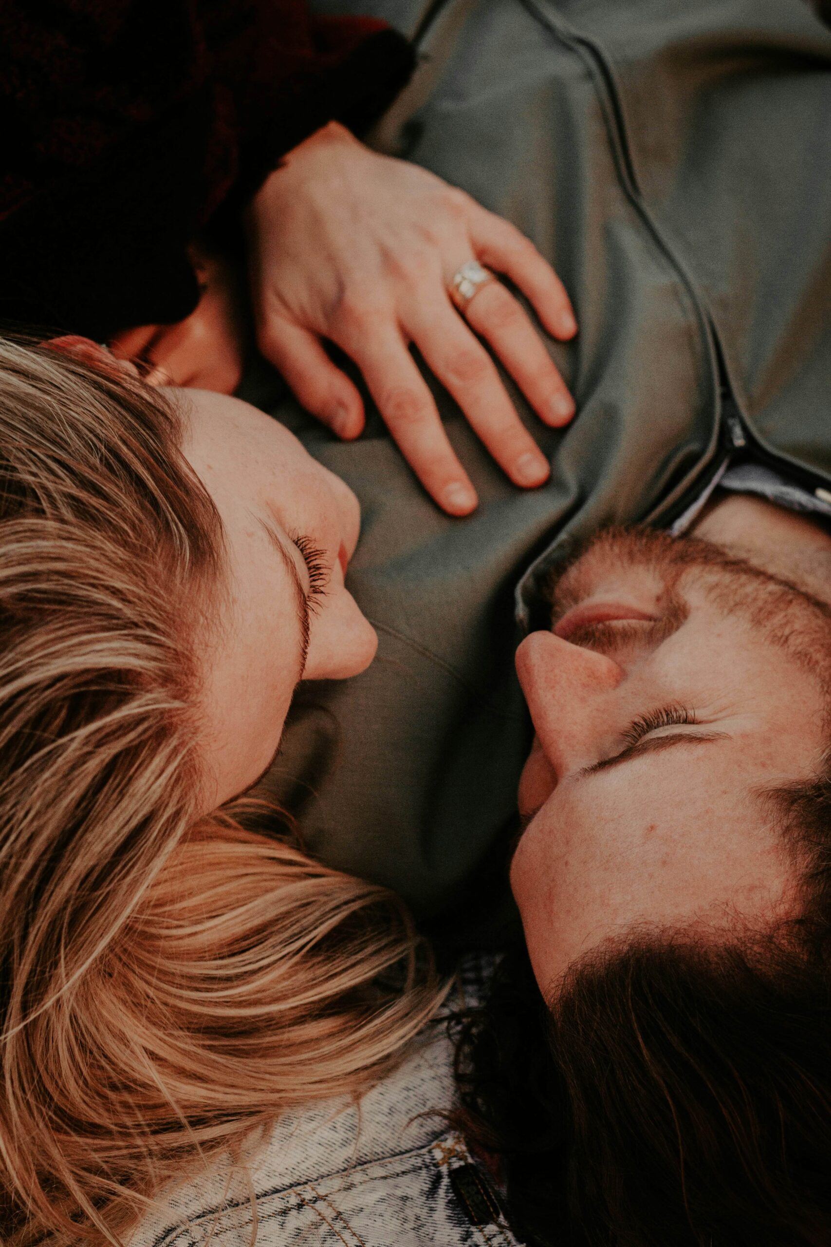 Image of a woman laying on a mans chest smiling at each other. Learn to rebuild trust in your relationship after cheating with the help of a skilled couples therapist in Miami, FL.