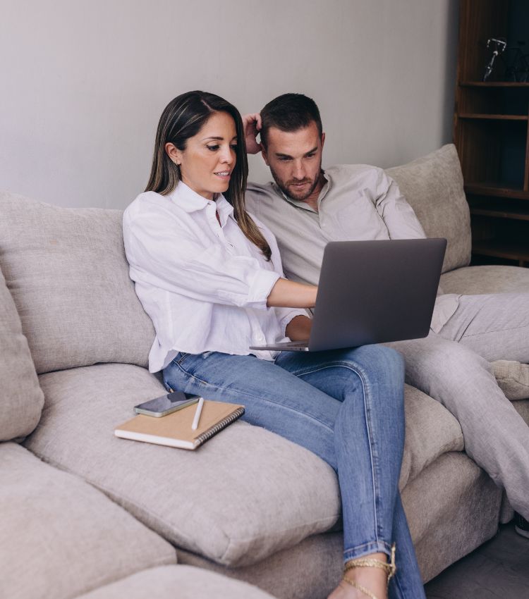 A couple sits together on the couch with a laptop, with a phone and notebook resting nearby. Ready to start couples therapy with a specialist team in Florida. This is for couples who've learned what to know before using insurance for marriage counseling and are asking whether insurance covers couples therapy the way they expected. Exploring insurance for couples therapy options built around their relationship in Port St. Lucie, Pembroke Pines, and West Palm Beach. Schedule a consultation to find the right fit for your marriage.